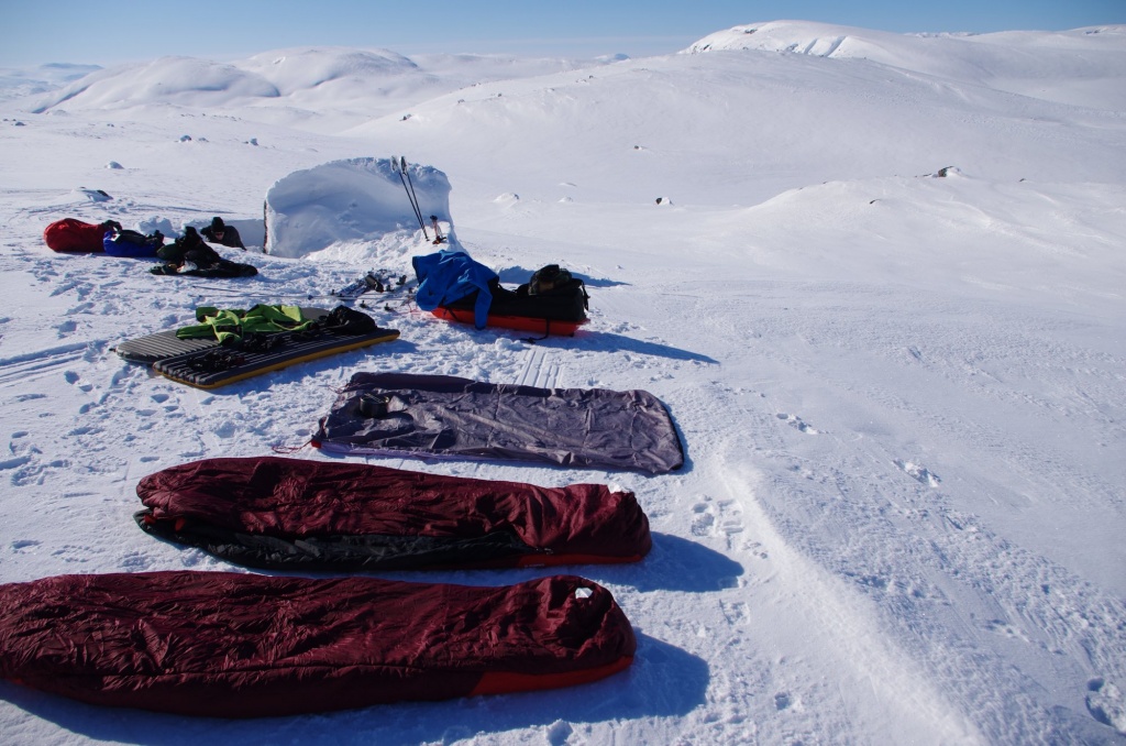 Isomatten, Schlafsäcke und Ausrüstung zum Trocknen im Schnee