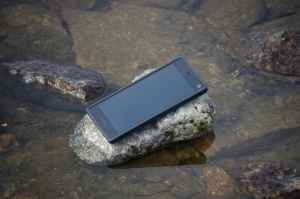 Fairphone 2 auf Stein im spiegelglatten Wasser