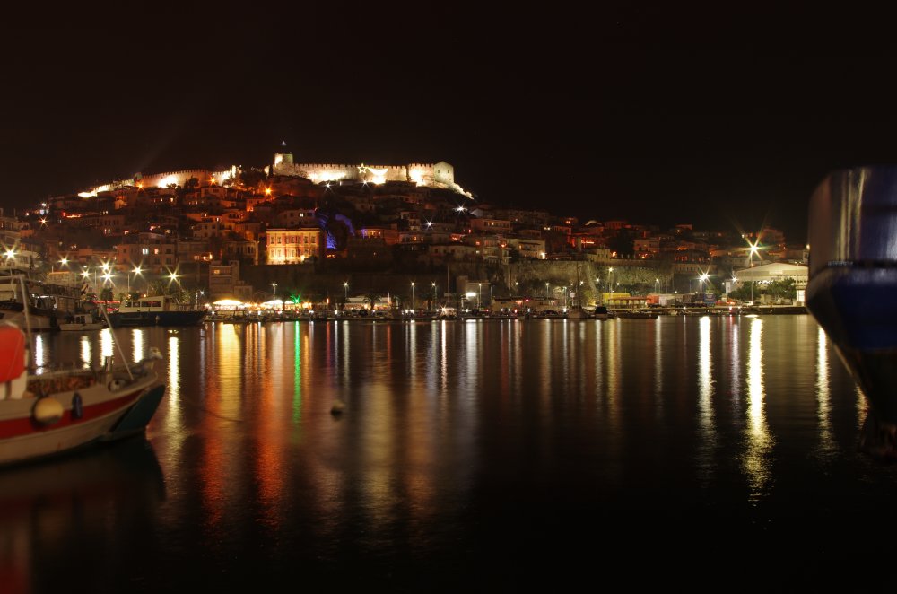 Nachtaufnahme der Handelsstadt Kavala in Nordgriechenland mit beleuchteter Festung, Hafen und Altstadt